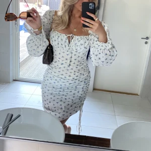 Adoore klänning - Vit klänning med små blå blommor, i modellen ”Capri” från Adoore. Endast använd två gånger, klänningen är i mycket gott skick. Storlek 36. Passar XS-S. 🫶🏼🦋