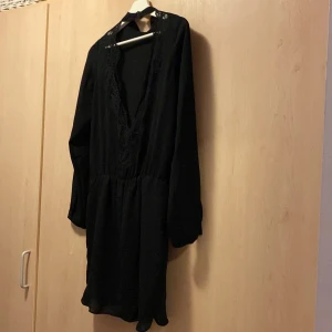 Klänning spets i tyggen  - Söt klänning hög i halsen spets i ryggen 