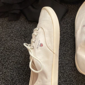 Gant sommarskor - Vita tygskor från gant som har en snörning framtill. Storlek 39 och skicket är väldigt bra för att vara vita tygskor. Använt fåtal gånger på skolavslutningar osv annars helt oanvända. Pris kan diskuteras vid snabb affär.
