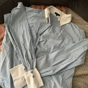 Snygg blå randig skjorta som inte kommer till användning! Står att det är en storlek 42 men skulle säga att den är mer som en S