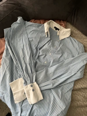 Randig skjorta - Snygg blå randig skjorta som inte kommer till användning! Står att det är en storlek 42 men skulle säga att den är mer som en S