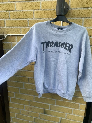 Thrasher Sweatshirt  - Grå oversized sweatshirt från thrasher. Köpt på Beyond retro oh inte använd mycket efter det. Står strl s i men isåfall är den ganska oversized. Passar även M. Köpt för 700 men säljer billigt för vill bara få bort den.