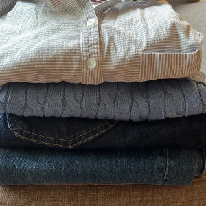 Klädpaket blå  - 1 randig skjortklänning från Bondelid stl 36  1 stickad tröja med flätat mönster och rund hals stl S 1 par jeans från Lee stl 34-32 1 par jeans från Asos stl 28-30  Allt i superfint skick!  120 kr plus frakt för alla plagg 