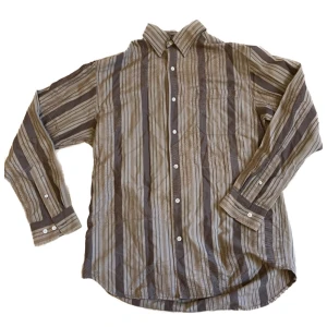 Brun skjorta - Stor härlig skjorta som funkar lika bra som utanpåskjorta eller buttondown! Storlek lite oklar, står S men jag tror det är amerikanska herrstorlekar. Hursomhelst skitsnygg som oversize! Färgen är bättre i verkligheten (mest lik sista bilden). 