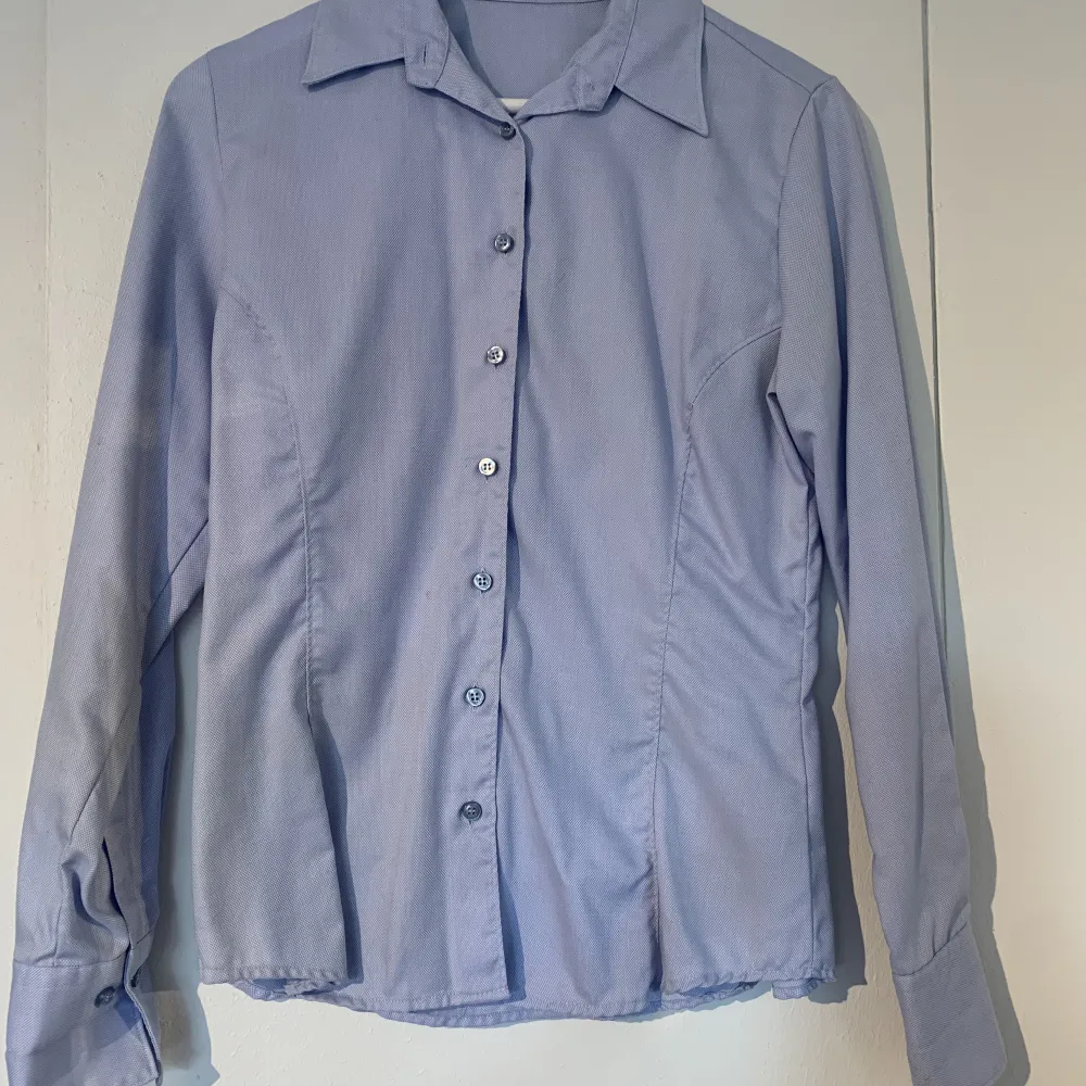 Ljusblå skjorta från Bosweel stl 38, skulle säga att den är mer stl 36. Liten fläck som inte gått bort i vanlig tvätt men ej provat med fläckborttagningsmedel.. Skjortor.