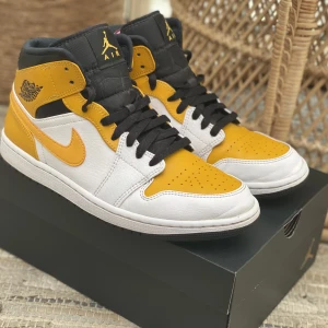 Air Jordan 1 Mid White/University Gold-Black - Jordan 1 Mid University Gold. Storlek 42. Köpta på Stadium Goods. Använda några gånger, fortfarande bra skick. 