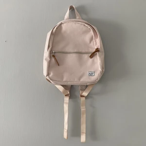 Jättesöt rosa ryggsäck från Herschel - Söt liten ryggsäck från Herschel :) Fint skick då den knappt är använd, finns väldigt små ljusgråa märken på framsidan, syns knappt dock.  Dimensioner enligt deras hemsida: H: 33 cm x W: 24 cm x D: 11 cm