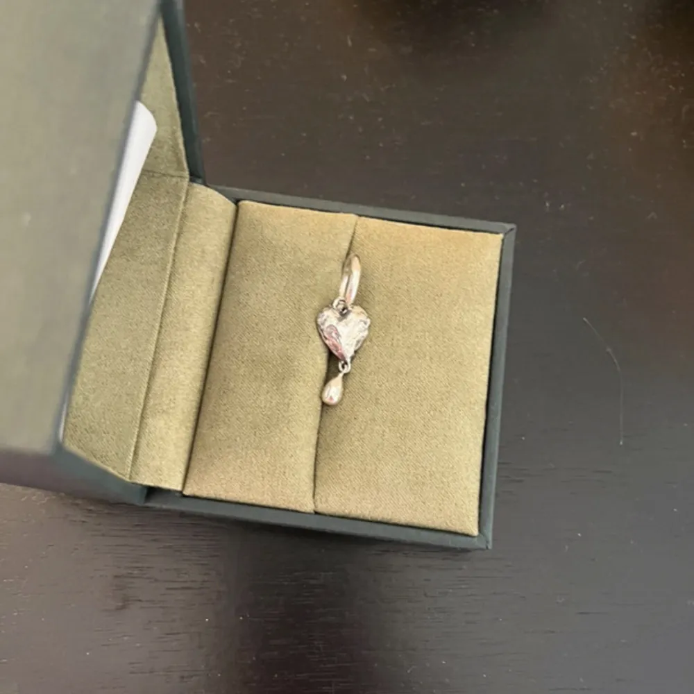 Crying Heart earring i oxiderat silver från Maria Nilsdotters senaste kollektion (funkar även som halsbandsberlock. Superbra skick. Säljer då jag mest använder guld. Kan tänka mig byten. Inga skambud 💓Org pris 2195 kr. Box medföljer. Accessoarer.