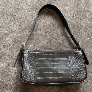 Väska - En svart väska i nyskick från gina tricot. Använd 2-3 gånger. Justerbart axelband.