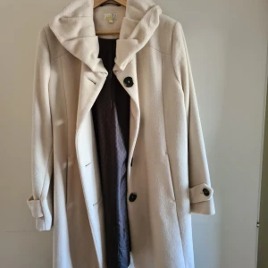 Kappa - Vit lång kappa från Isolde. Använd men i jättefint skick. I vaniljvit färg