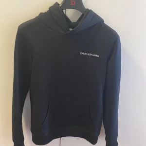 Calvin Klein jeans hoodie  - En Calvin Klein hoodie i ny skick. Har storlek S/M.  Inte så användbar för mig längre då det inte är min stil. 