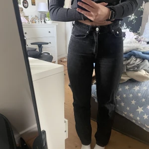Weekday Rowe Extra High Straight Jeans - Svarta straight jeans med hög midja, i storlek 25/30. Något tajta över höfter och lår på mig som vanligtvis är en 25-26 i midjan. Väl använda i gott skick. Originalpris: 590 kr