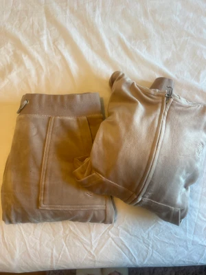 Juicy couture  - Säljer mitt nästintill oanvända juicy set i en beige/rosa färg. Pris kan diskuteras :) Byxorna är i stl S Tröjan är i stl M