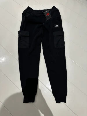 New Balance Fleece Byxor - New Balance träningsbyxor med fleece inuti. Storlek S. Aldrig använda med tags. Svarta med många fickor 