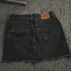 Levis kjol - Snygg svart kjol från levis. Midja på 26