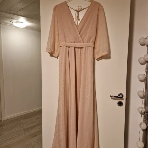 Långklänning - Långklänning som är ljusrosa. Sparsamt använd. Den är från Vila. Strl M