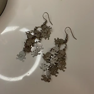 Örhängen med dödskallar.   - Skit snygga örhängen med dödskallarna. I färgen silver, som ni kan se på bilden så har dem som ett mönster som får dem att skimra nästa. 