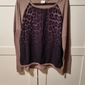 Långärmad tröja  - Säljer denna tröjan från Ginatricot i storlek L, den är brun och lite beige, på framsidan har den leopardmönster som är lite genomskinligt, väldigt skönt och tunt material, använd väldigt få gånger 