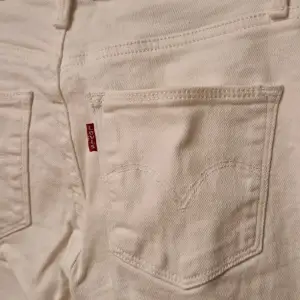 Vita Levi's jeans i modellen slimming slim. Avklippta, passar ca. 160-167 cm lång. Storlek 25