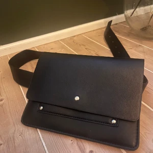 Carina wester väska -  Carin Wester svart väska Storlek: ca 20x15cm Material: fuskläder har 2 axelband i olika tjocklek som går att ta av och på. (Se bild) Färg: Svart Skick: använd 1ggr