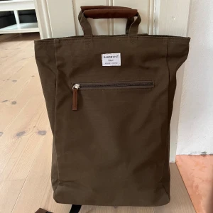 Ryggsäck Sandqvist  - Ryggsäck från Sandqvist, ground-serien. Perfekt vardagsryggsäck med plats för dator/ipad. Praktiska handtag om man hellre vill bära den i handen än ha den på ryggen. Sparsamt använd.   Skickas mot fraktkostnad. Alternativt hämtas i Falun eller Gagnef.