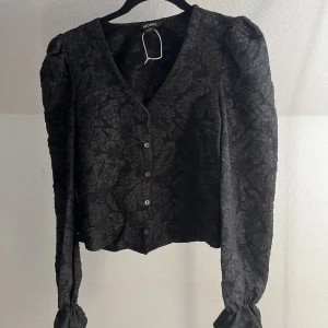 Blus - Svart, mönstrad blus från monki. Aldrig använd (prislapp har ramlat av men tråden sitter kvar😅). 