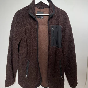 Teddyjacka - Teddyjacka i en fin brun färg. Köpt på lager 157. Endast provad så skicket är som nytt. Nypris 300kr. Storlek S
