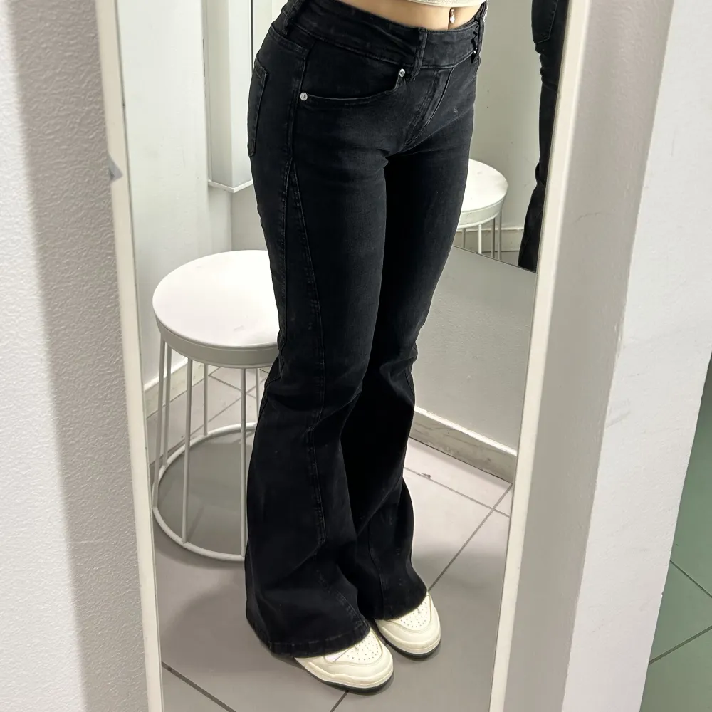 Grå/ svarta låg midja de bootcut jeans med cool detalj. Endast testade. Sitter perfekt på mig som är 165 cm🖤. Jeans & Byxor.
