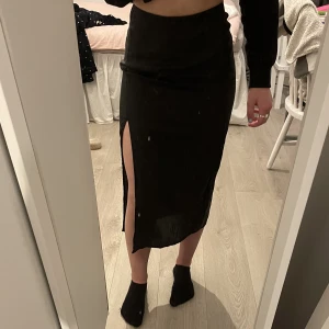 Svart kjol med slits  - Säljer min svarta kjol från H&M i storlek XS. Har inte använt den ofta så den är i väldigt fint skick. Jag är lite osäker på vad det är för material men står ”lyocell”. 30kr