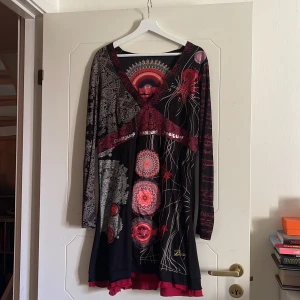 Långärmad kort klänning - Knappt använd svart/röd klänning med typiskt Desigual-mönster. 