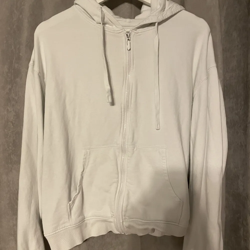 Vit zip up hoodie liten i storleken är storlek M men passar mer S lite färg har släppt från dragkändigan se bild 2. Hoodies.