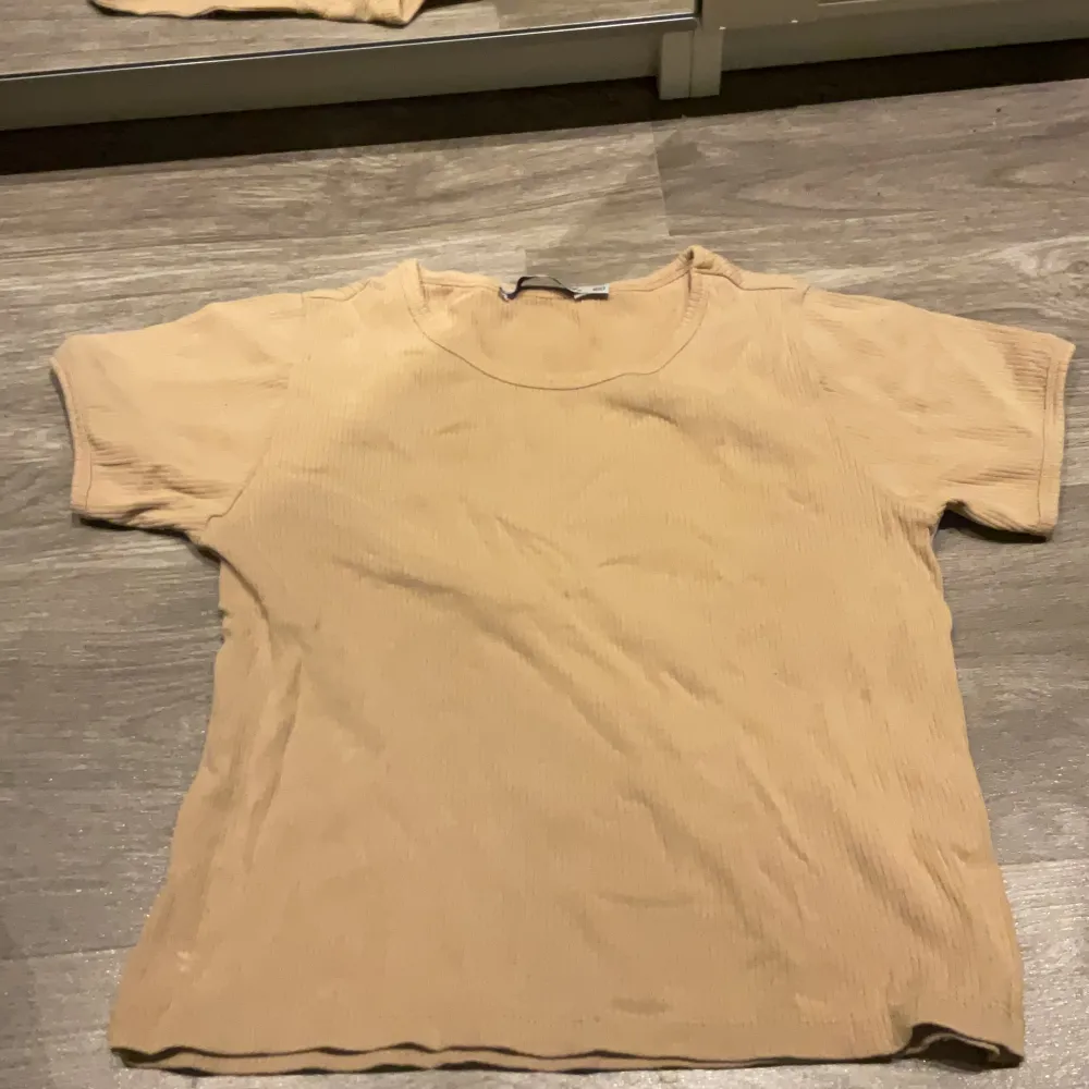 Ljusbrun ribbad t-shirt i skönt material. Säljer pga för liten. T-shirts.