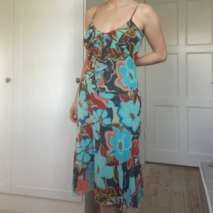 Volangklänning med blommor - Klänning med meshtyg, volanger och blommor. Inga defekter, storlek M. Från Massimo dutti