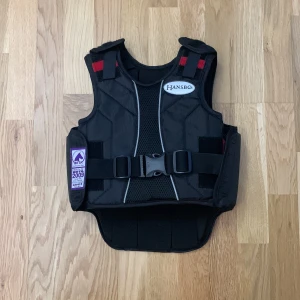Ridväst hansbo - Jag säljer min ridväst då jag har fått en ny. Den har kardborre på sidorna med ett spänne för att sätta fast västen. På baksidan finns det reflex. Pris kan diskuteras vid snabb affär.