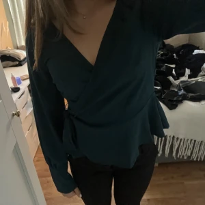 Grön blus  - Säljer min superfina gröna blus, med knyte i sidan, den är nästintill oanvänd! Köpt för 499. (Frakt ingår ej,skriv för fler bilder💗)