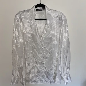 Skjorta - Så cool skjorta! Köpt på humana. Glansig med blommor på, oversized och väldigt tunn och skön i materialet 
