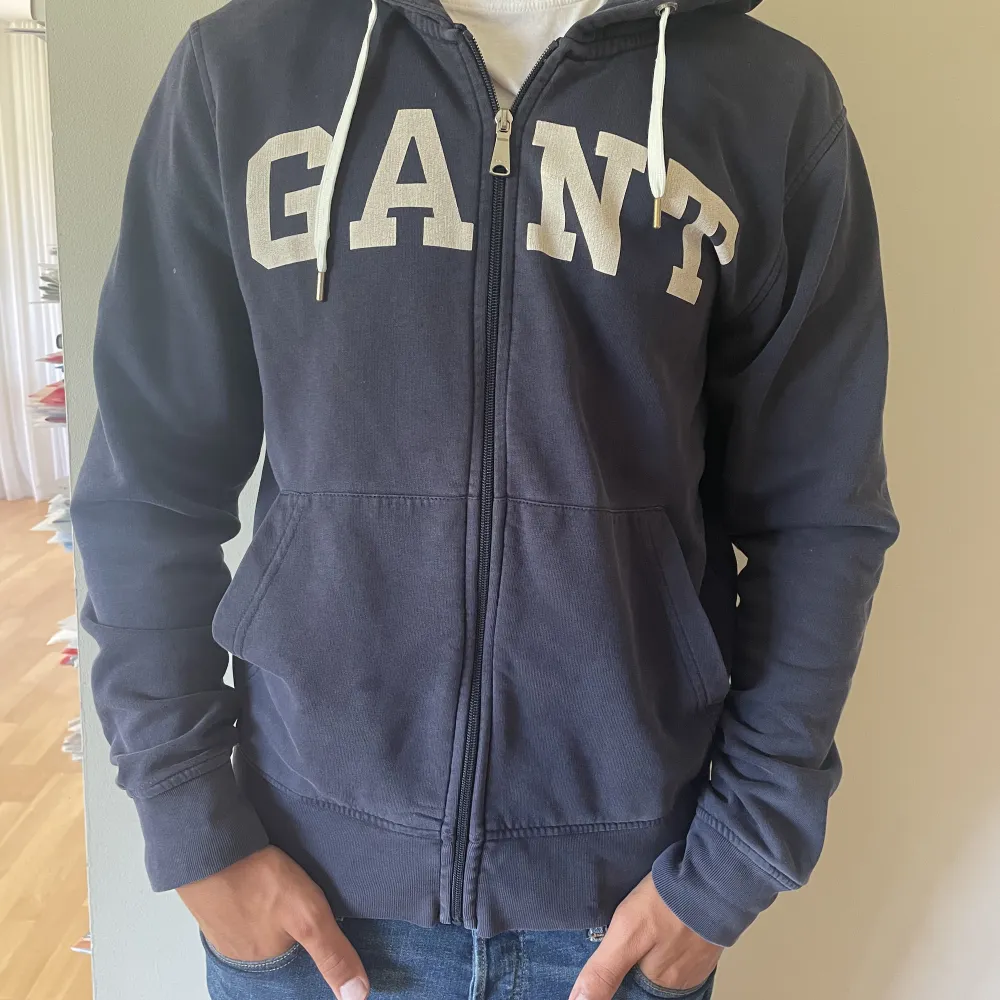 Säljer nu en väldigt snygg hoodie från märket Gant. Blir perfekt till sena sommarkvällar och mot hösten. Den är i storlek Large. Den är i bra skick utan defekter. Personen på bilden är 186cm. Hör av er vid funderingar!. Hoodies.