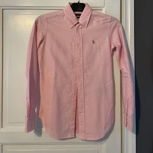 Ralph Lauren skjorta  - Rosa skjorta från Ralph Lauren storlek 0. Modell super slim fit. Använd 1-2 gånger. 
