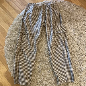 Cargobyxa Sweet SKTBS - Cargobyxa från Sweet SKTBS, köpt på Junkyard. Fickor fram och bak, går att dra åt i midjan, straight fit. Storlek S (Unisex).  Inköpspris 599, säljs för 250kr