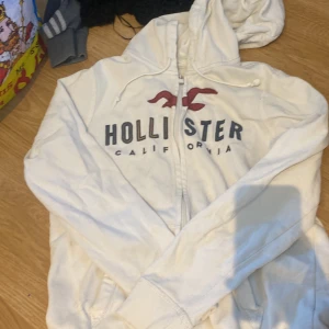 Hollister huddie - Vit hollister huddie i andvänt skick därav priset 30 kr. Missfärgningar på texten och lite strulig dragkedja. Den är i herr Small. Så Dam M