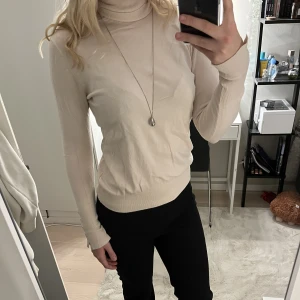 Populär Zara tröja - Beige turtelneck tröja ifrån zara med detaljer på båda ärmarna!! Den är lite skrynklig eftersom att den nt har kommit t användning med det är inget som inte går bort!