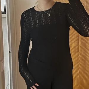 Tröja i spets - Långärmad tröja i spets från Lindex. Ärmarna är långa och går ner halvvägs över händerna. Nyskick.