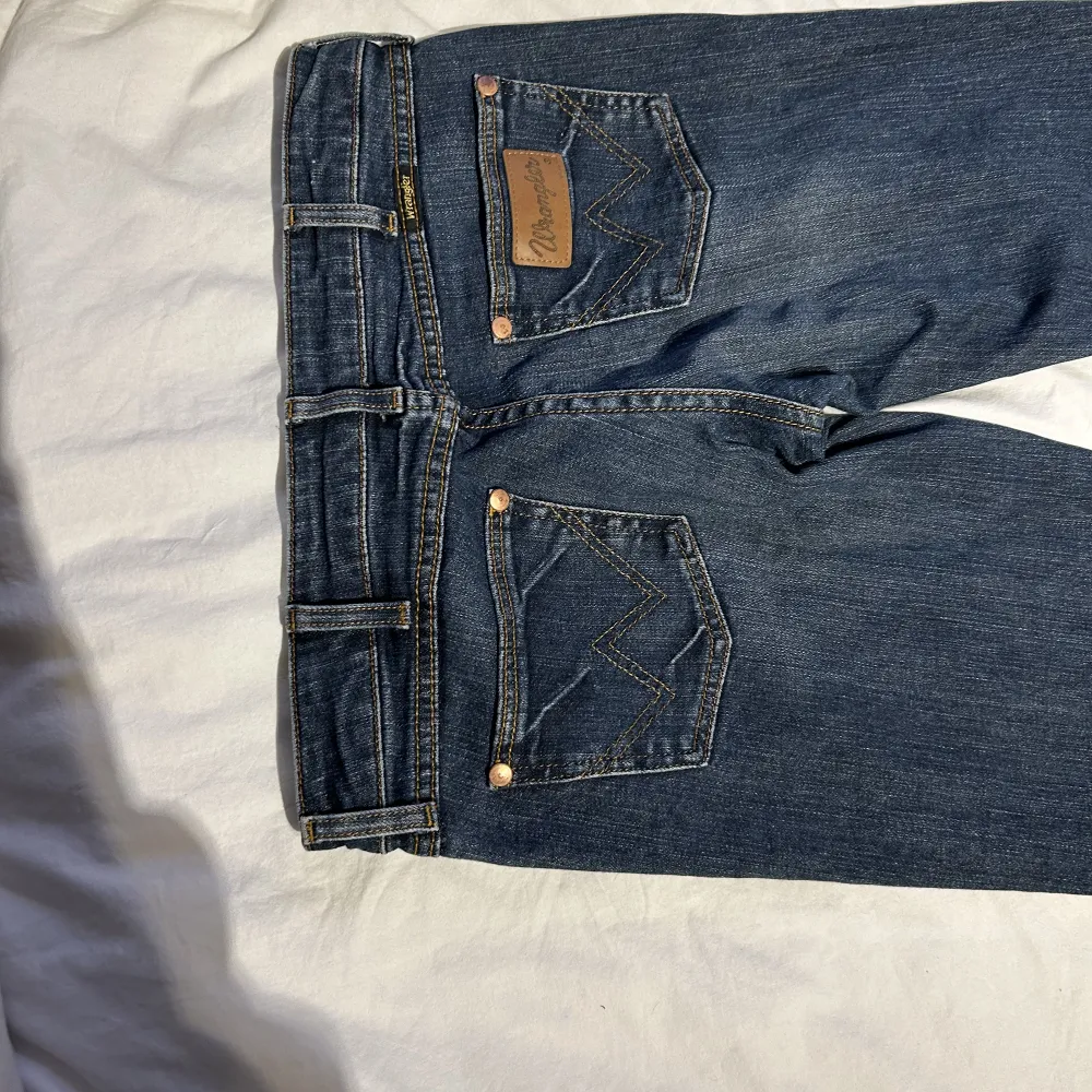 Säljer dessa jättesnygg jeans den Wrangler  Storlek w 39 L 34  Midja 39 cm Insida ben 80 cm Total längd 104 cm. Jeans & Byxor.