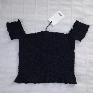 Oanvänd! Svart crop top - smockad topp - storlek S - Svart croppad topp från Bik Bok. Smockad, mjuk och stretchig. Storlek S. Så snygg och användbar. 50% bomull och 50% viskos. 