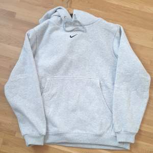 Den mycket populära och eftersökta Grå Nike Center SWOOSH hoodie i grå/vit färg.  10/10 Condition I storlek M! 