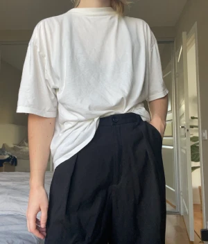 Svart kostymbyxa - Svarta kostymbyxor med high waist. Flowy byxor nedtill (se sista bilden) som sitter med resårband vid ryggen (stretchig). Kommer med bälte. Storlek: XS-S (liten M)