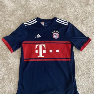 Bayern München 17/18 away kit - Tröjan är köpt i München 2018 Den är i väldigt bra skick, 8,5/10  På tredje bilden ser du att det inte är något plastigt märke utan det är sytt in och är äkta.
