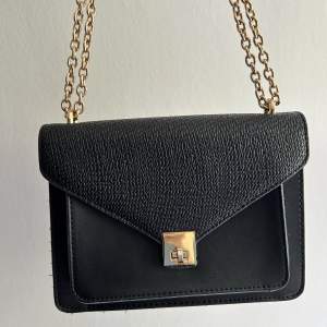 Säljer denna svarta handväska med guldkedja. Är i jättebra skick. Har ett innefack. 