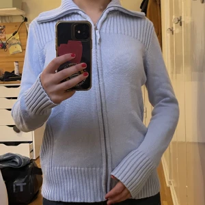 Marks & Spencer stickad tröja - Jättefin stickad/ vin stickad zip upp tröja som är väldigt trendigt just nu! Jättefin ljusblå färg utan några defekter