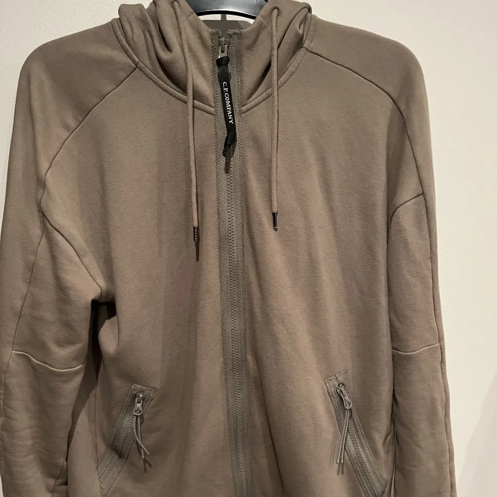 Cp company hoodie storlek L. Jag bär vanligtvis storlek M och den passar mig. Tröjan säljes pga av att den inte kommer till använding längre. Tröjan är köpt på Cenino i Växjö för cirka ett år sedan, köpt för 2500. Se sista bild för ända deflekten påtröjan. Tröjor & Koftor.